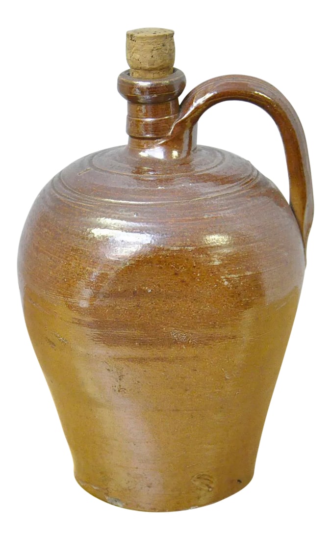 Vintage French Jug: Vintage French Stoneware jug from the Brittany region of France. This jug has its original cork and was used to hold apple cider or milk on the farms in this region of France. It has a glazed finish.