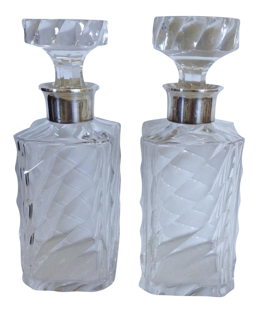 Pair of Crystal Decanters W/ Sterling Collars: Matching pair of heavy crystal cut decanters with matching stoppers each fashioned with a swirling pattern and sterling collar. '925' sterling mark on each. Condition: Alterations: Original Condition