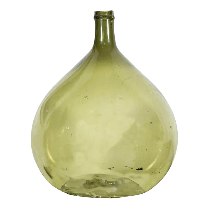 19th Century French Green Glass Demijohn or Dame Jeanne Hand Blown Bottle: A beautiful 19th century French handblown green glass demijohn or Dame Jeanne bottle, circa 1880s, having a bulbous shape and brightly colored green glass with visible bubbles and no seams, an indicat