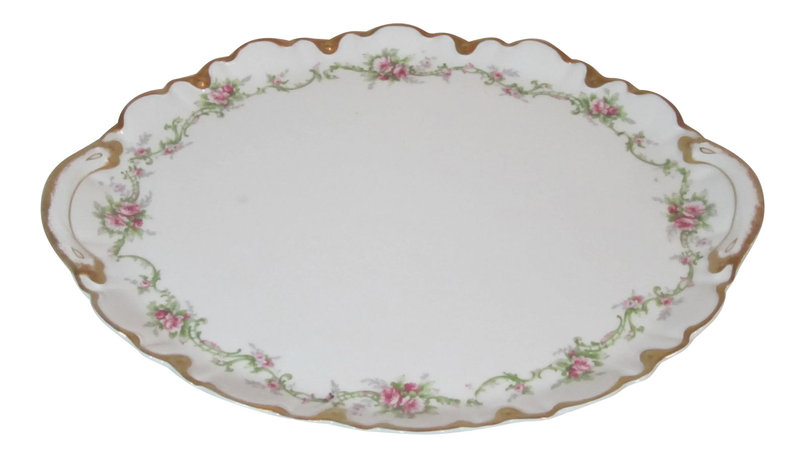 White Floral Gold Rimmed Limoges Theodore Haviland Platter from the 1940s: Wonderful oval shaped Haviland Limoges serving platter. It has a scalloped edge accented with gold. Hand painted floral swags and roses decorate the boarder. Condition: Alterations: Original Condition
