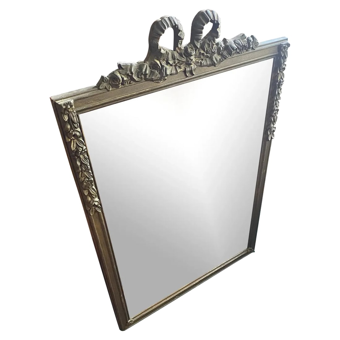 Antique 1920s French Ribbon Cartouche Carved Wood Wall Mirror: This stunning antique wall mirror dates to the 1920 and showcases exquisite French-inspired craftsmanship. The frame features a carved floral swag motif down each side and a dramatic double-looped rib