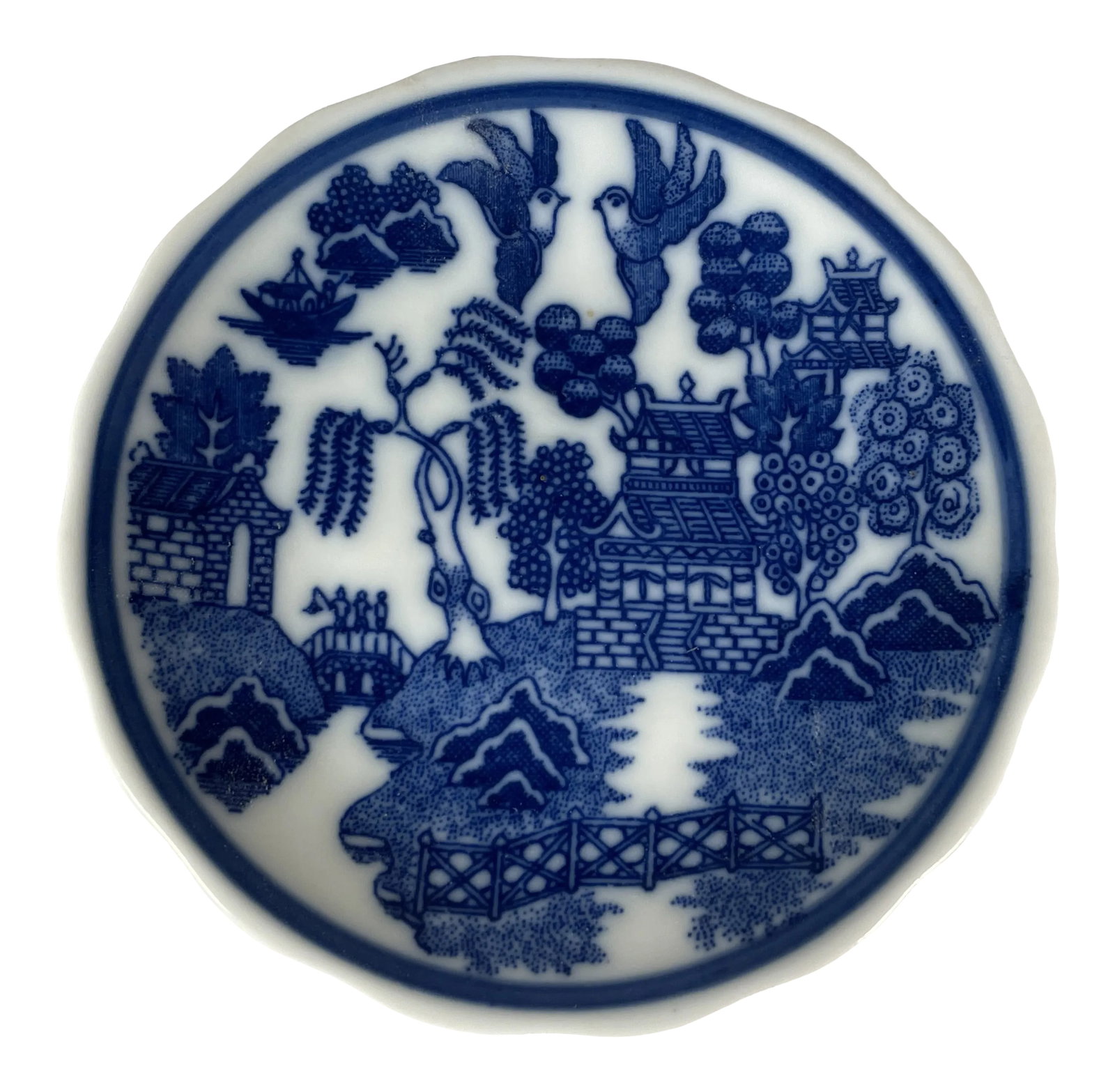1960s Miniature Blue Willow Pattern Scalloped Edge Saucer, Japan: This stunning miniature saucer is done in the traditional blue willow pattern and has a unique scalloped edge. It has a "Made in Japan" sticker on the back and probably dates to around 1960. PLEASE
