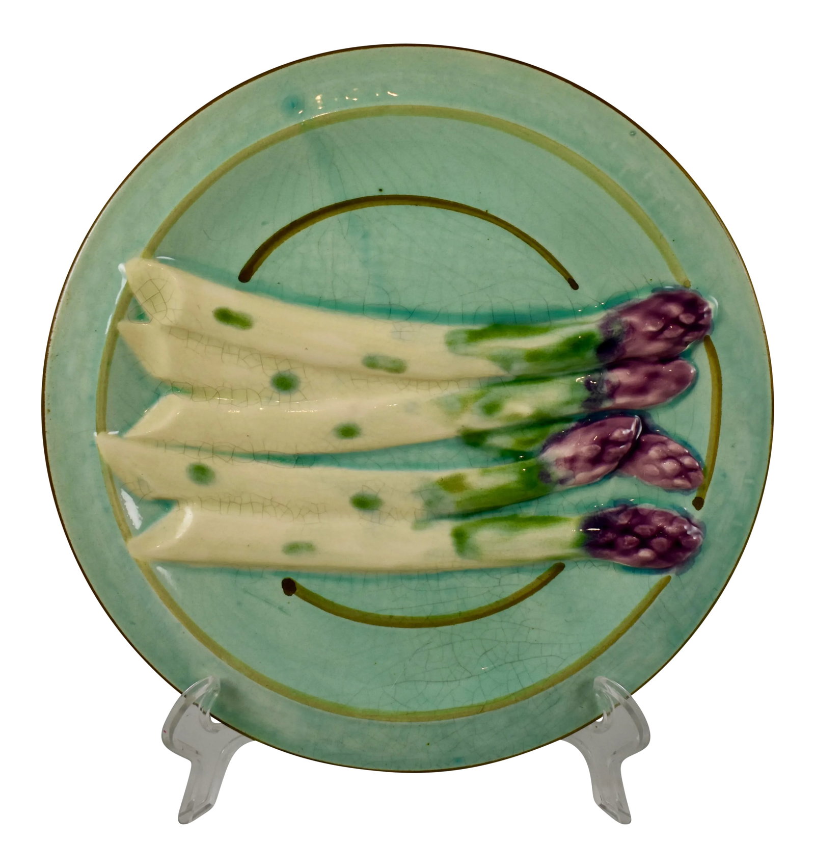 Sarreguemines French Faience Turquoise Asparagus Plate: A French Faience asparagus plate, showing a group of five asparagus spears spread across a turquoise ground. A hand-painted border line and a faint basketweave pattern on the rim. Great color. Book Re