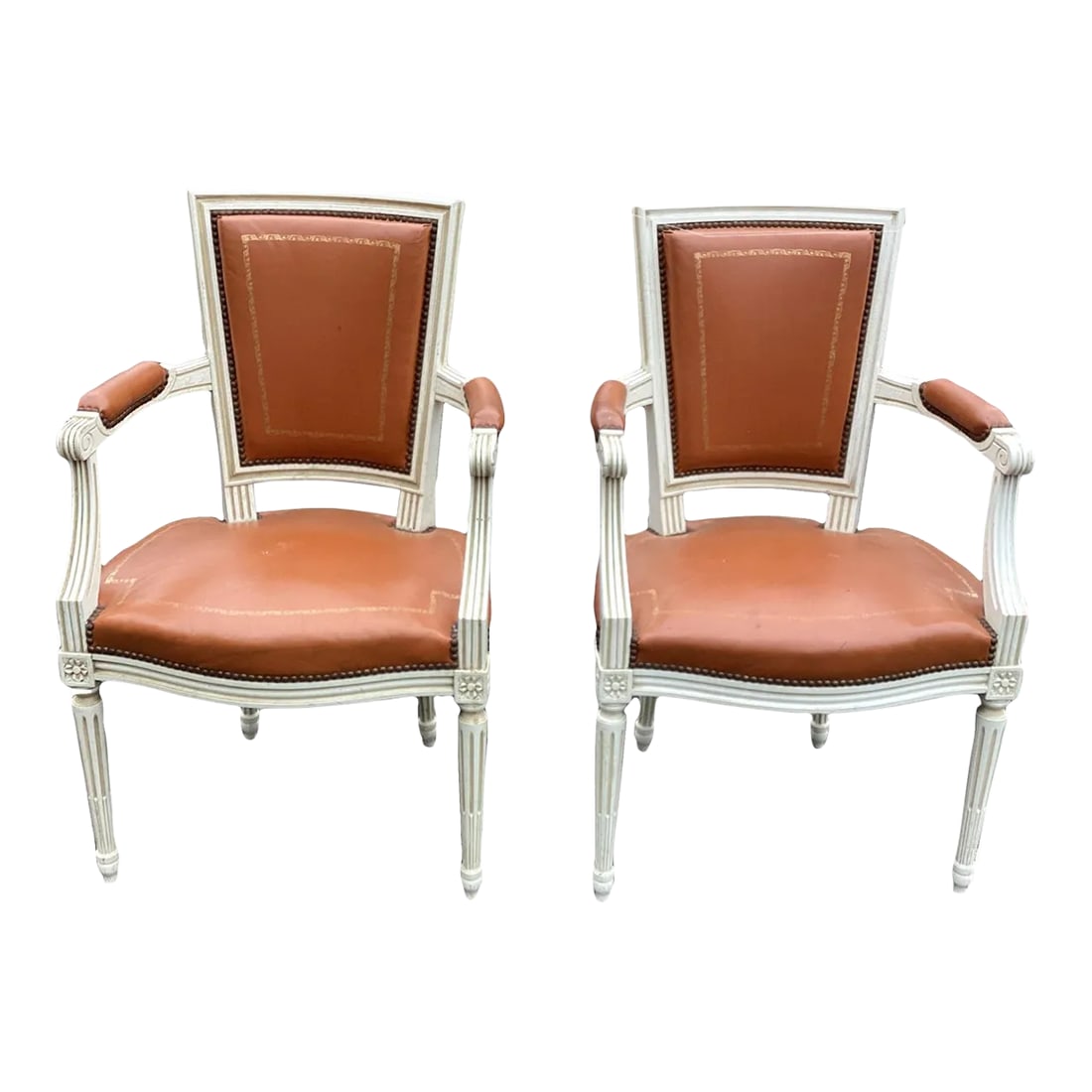 1950s Vintage Louis XVI French Leather Painted Chairs - Set of 2: This is a classic pair of Louis XVI-style leather chairs. The frames feature a square back with a scalloped seat, straight fluted legs and carved floral motifs at the top of the legs. The upholstery