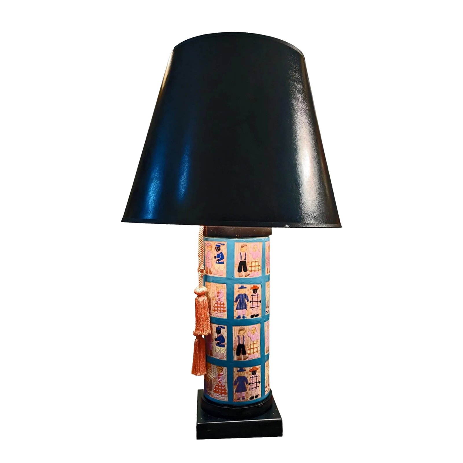 1960s Hand Painted Folk Art Quilt Inspired Table Lamp Unsigned With Edward Shade: A table lamp that has a cylinder shaped body that is hand painted with a series of square shaped iimages that are presented in a quilt pattern. The gridlines that seperate the tile-like squares is pre