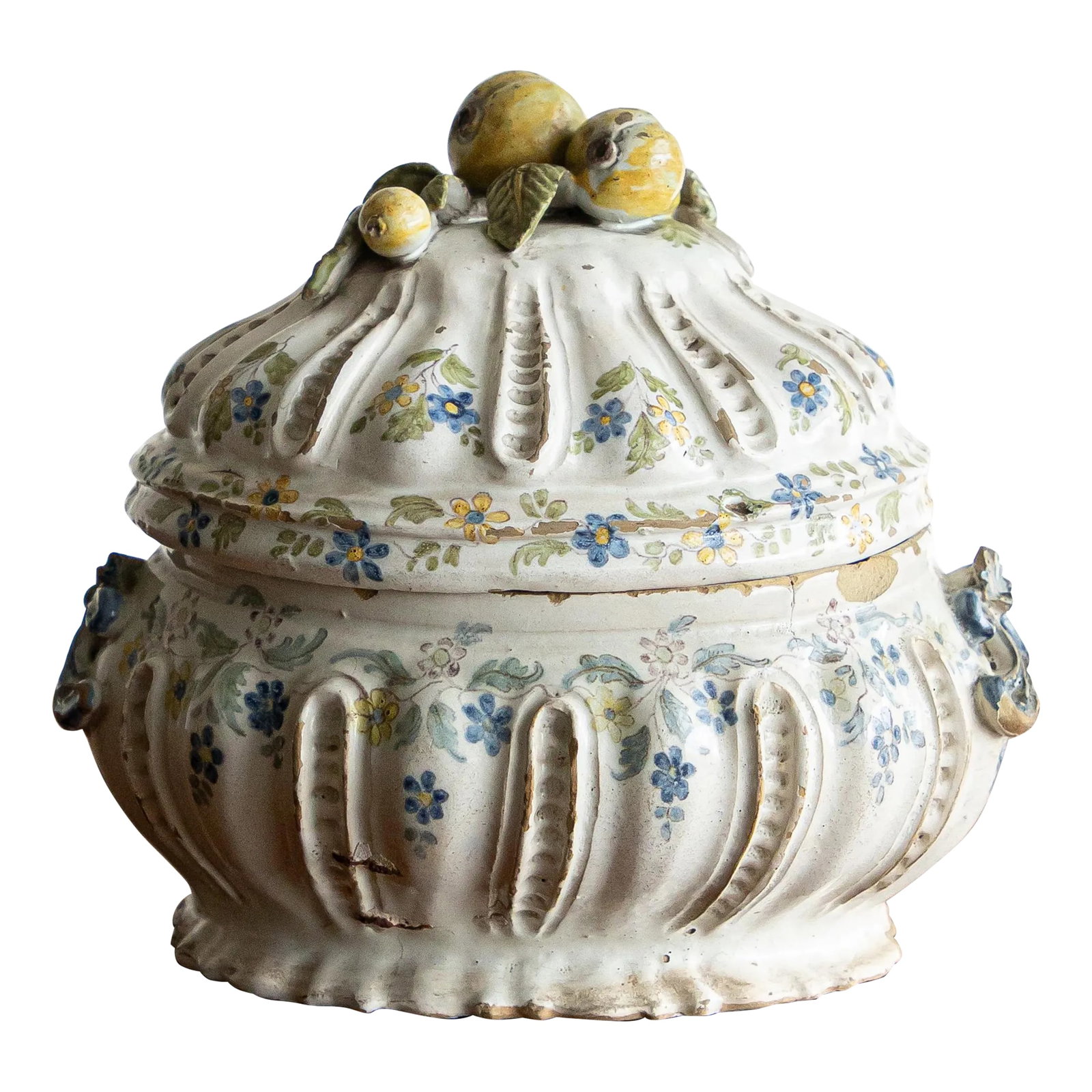 18th Century Italian Tureen: The oval tureen with ribbed walls rests on a flat base and features applied handles. The domed lid complements the shape of the tureen and has a beautiful lemon and pears on top. The decoration is