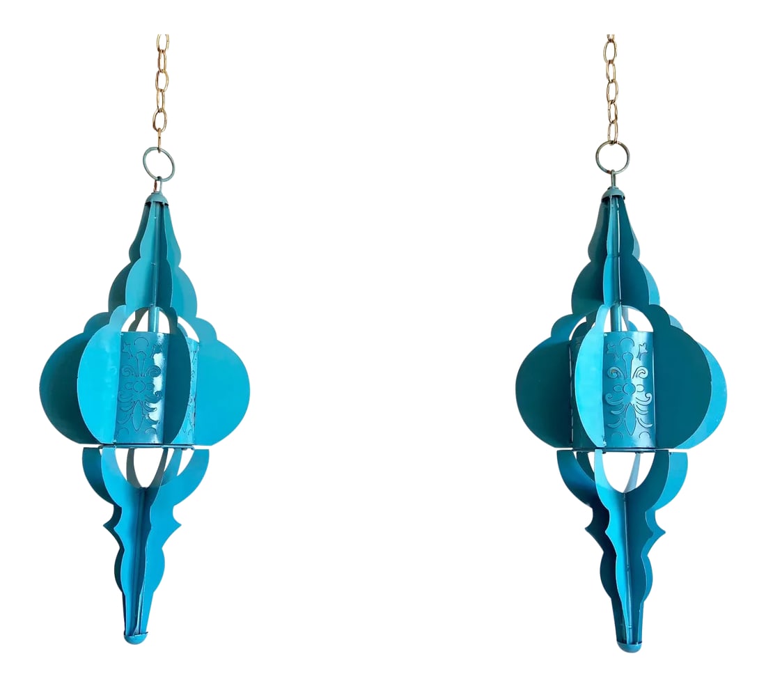 Modern Pierced Moroccan Pendant Lights, Pair: Gorgeous pair of large blue enameled Moroccan-style pierced metal pendant lights with elongated frames, rounded fins, and geometric cutouts lined in paper. Professionally restored with new wiring and