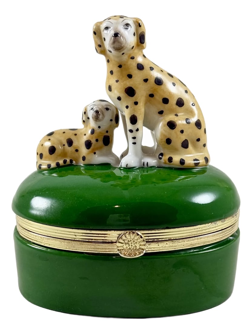 Fitz & Floyd Spotted Dogs Porcelain Trinket Box: From Fitz and Floyd, a charming porcelain Dalmation trinket box, 1985. Two yellow and black spotted dogs sit atop an oval, green glazed lidded box with metal bracing. The box closes tightly with a