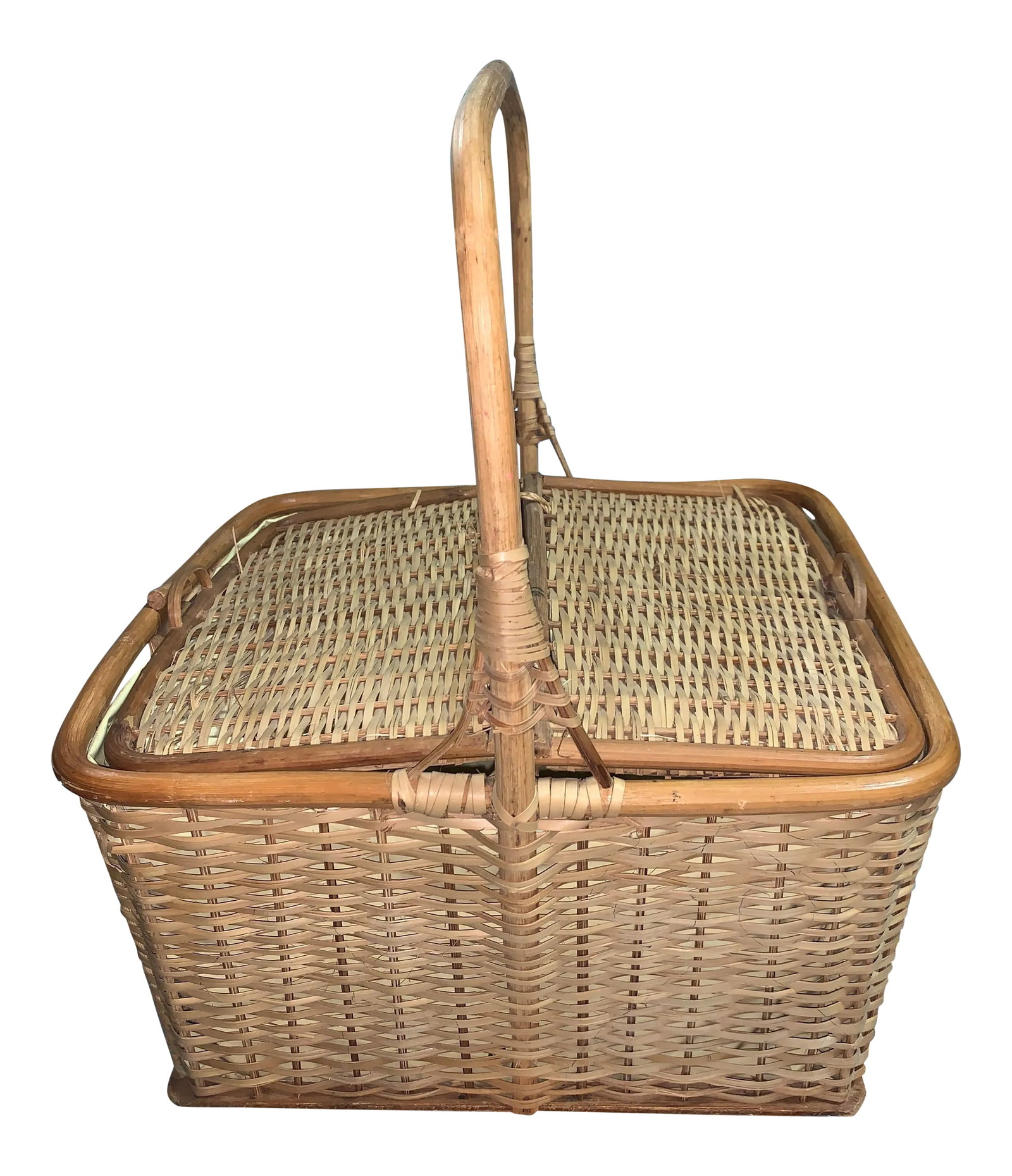 1970s Rattan Lined Picnic Basket: Vintage rattan picnic basket with a plastic lining. The item's exterior is in great shape, the plastic liner shows some discoloration. Was previously used to store cookbook pamphlets. Opens two ways.