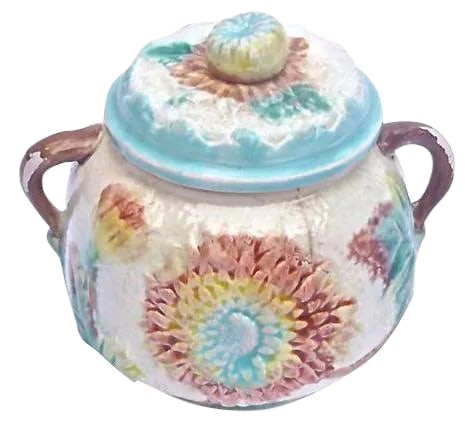 Antique Majolica Dahlia Lidded Bowl: Antique 19th-century French majolica dahlia floral lidded sugar bowl with vine-style handles. Floral and leaf design in relief on the body and lid. Condition: minor crack/wear to handle
