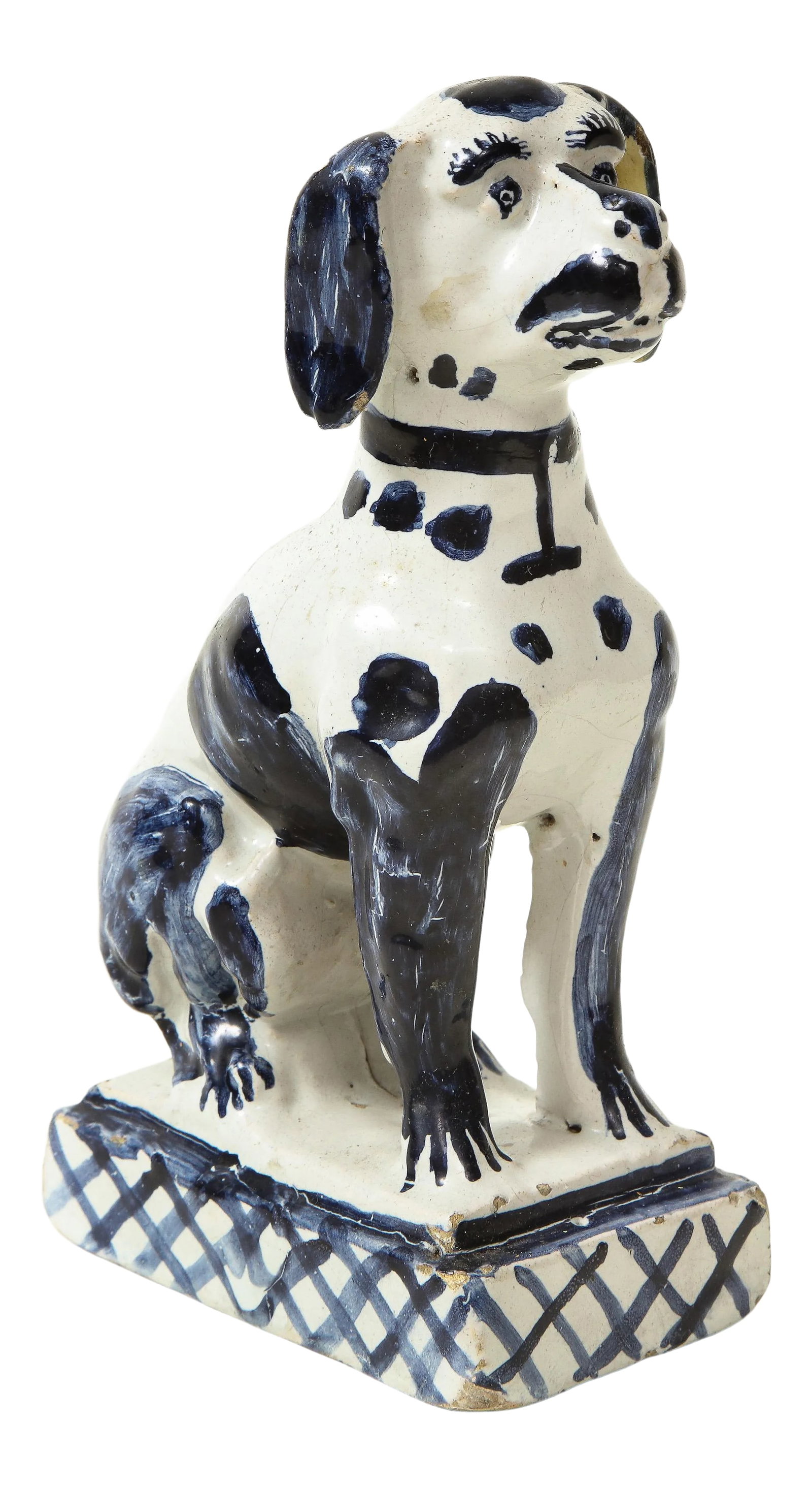 Delft Figure of a Seated Dog: Faience, painted blue. With spiny back and seated on a cross-hatched rectangular plinth base. Condition: Alterations: Original Condition Unaltered Imperfections: Some Imperfections Condition Notes: