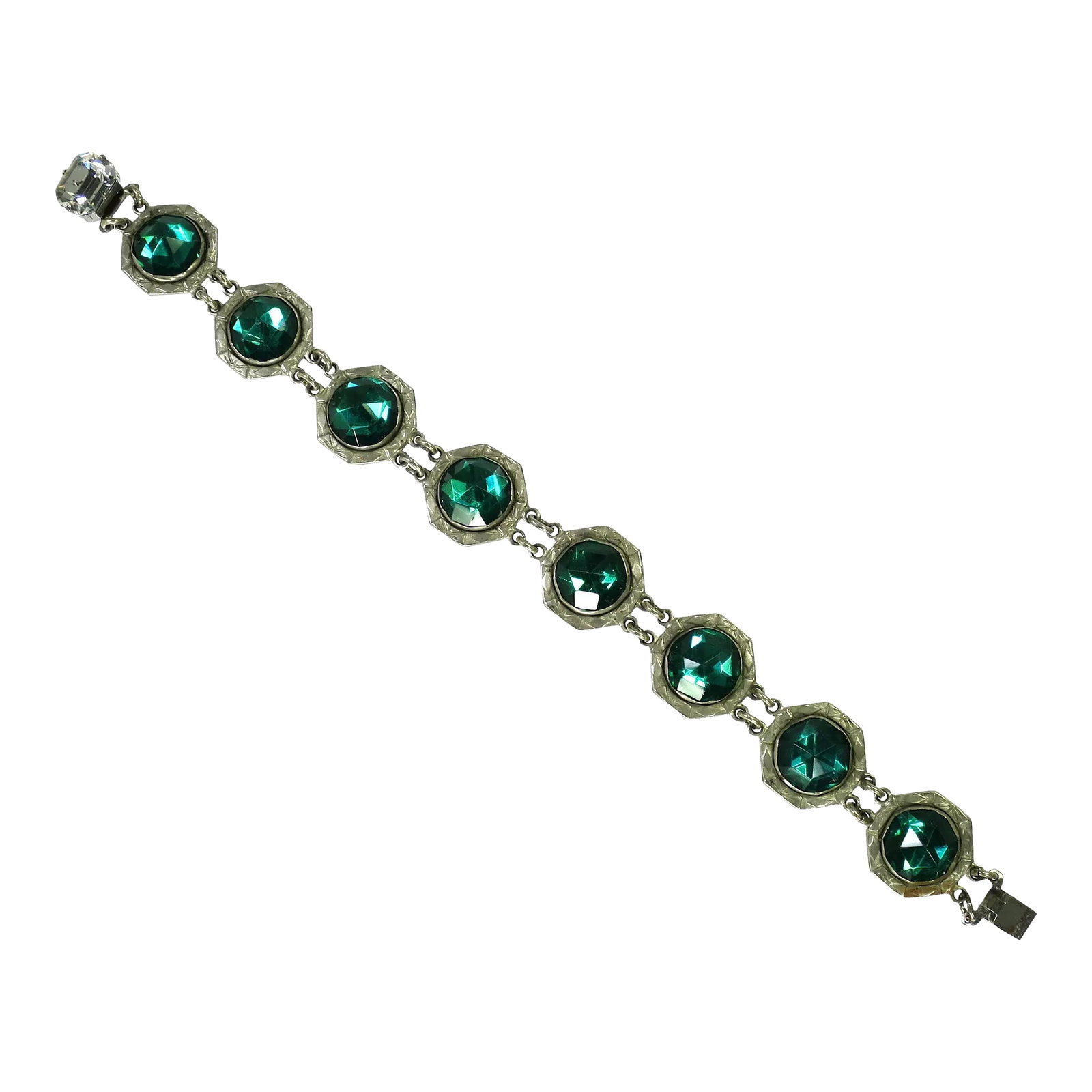Vintage 1920s Art Deco Emerald Vauxhall Glass Bracelet: This is part of Chairish's Costume Jewelry assortment. 1920s Art Deco silver-plated link bracelet. Linked hexagonal platforms are etched with geometric Art Deco designs surrounding emerald Vauxhall gl
