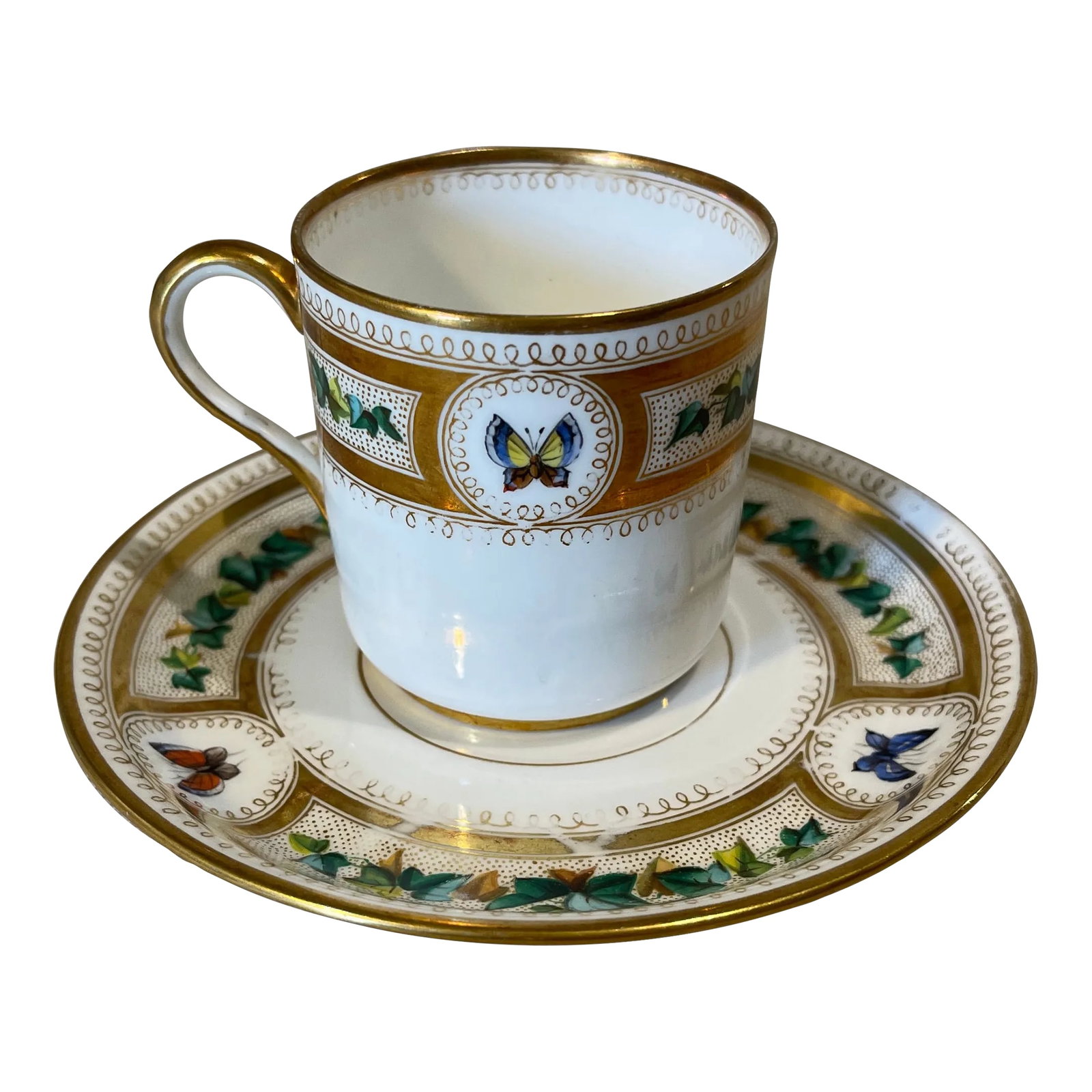 Mid 19th Century Westhead & Moore Butterfly Cup & Saucer: A rare Westhead & Moore porcelain cup and saucer for tea, coffee, or demitasse. White ground with gold gilt rims and looped design around an Ivy Foliate border interspersed with HandPainted butterfly