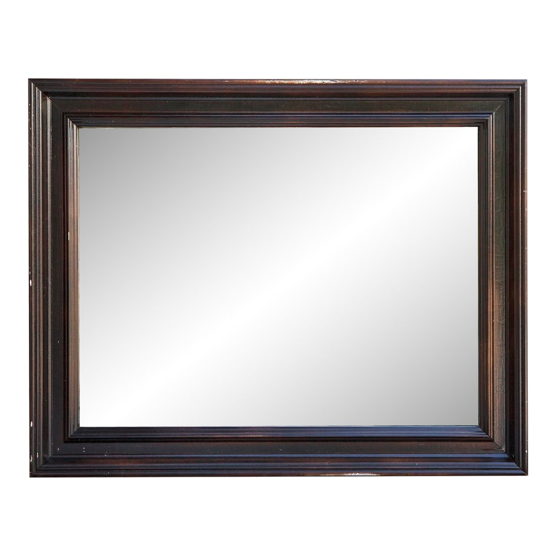 1970s Traditional Wood Framed Mirror in Dark Brown: A wood framed mirror featuring a rich brown stain applied over its original painted finish. The technique creates a layered effect that highlights the frames texture & depth. For an interior that