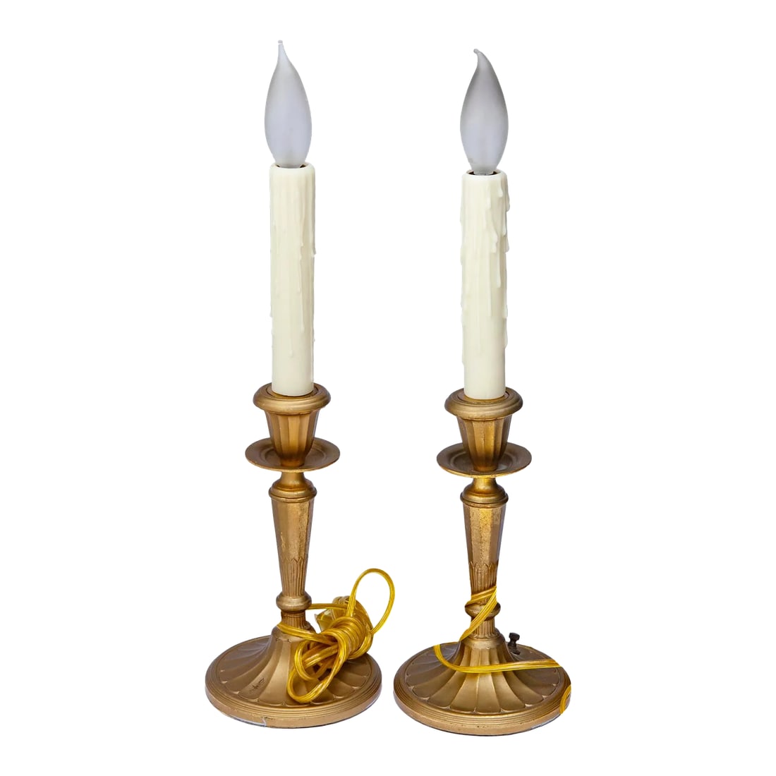 1940s Gilt Metal Candlestick Lamps, a Pair: Gilt brass candlestick lamps have been rewired using the original switch on the base. They have a fluted design on the candlesticks. The fluted gilt brass lamps rest on an oval base. They can be used 