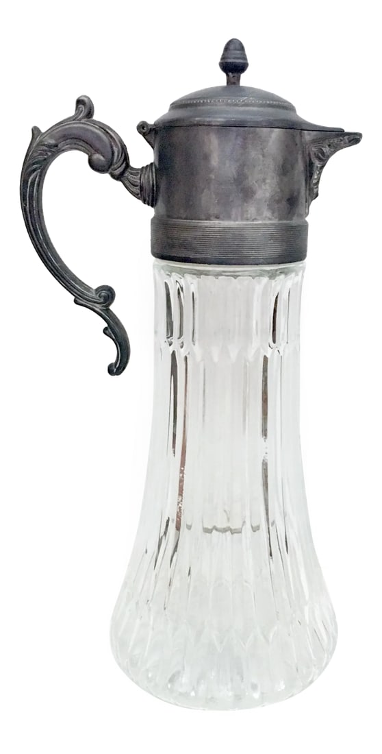 Glass and Silver Plated Pitcher: Ornate faceted glass pitcher with removable ice cylinder and silver-plated spout with handle. 10-inch tall glass body has one chip, see photo. Can be used with or without plastic removable ice