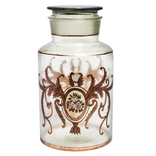 Antique Italian Apothecary Lidded Glass Jar: Fanciful lidded canister jar from Italy. Embellished with hand painted pink roses and gilded accents. Use this glass jar to store everyday essentials on a vanity or dressing table. Add a touch of