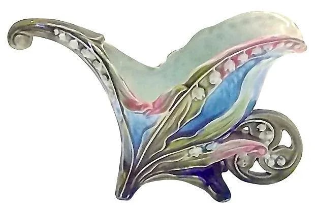Antique Majolica Floral Wheelbarrow Cachepot: An antique; 19th century, French, Art Nouveau-style, majolica, floral, wheelbarrow, ceramic cachepot. Art Nouveau-style lily of the valley supported by a decorated wheelbarrow. Condition: minor wear. 