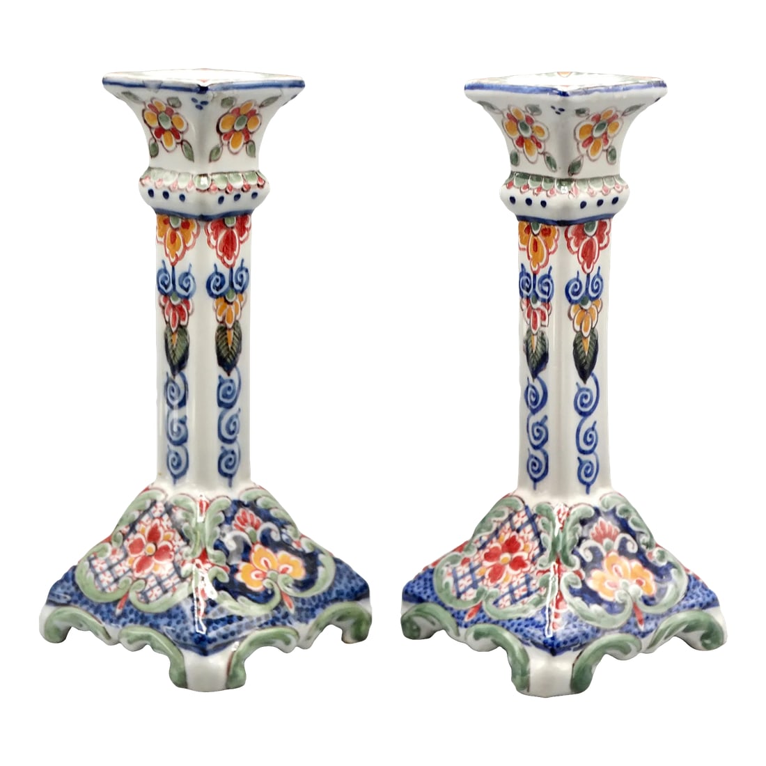 Dutch Delft Makkum Polychrome Candle Holders, a Pair: Pair of early 20th-Century Dutch Delft candlesticks 9" in height. They are hand painted in a colorful floral garden design comprised of a floral and foliate motif. Marked on the reverse, Makkum, a