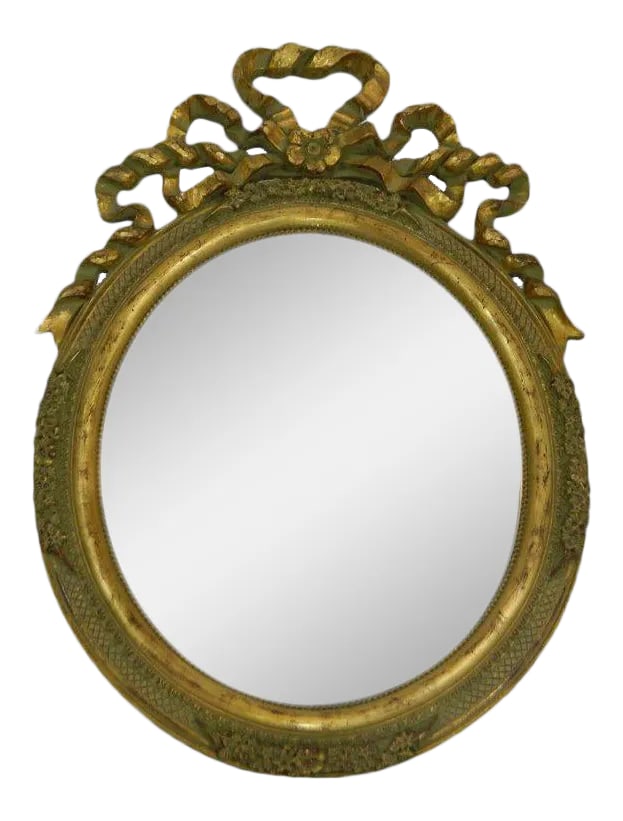 Italian Hand-Carved Gold Leaf Oval Vanity Mirror, 20th Century: Early 20th century Italian hand-carved gold leaf oval vanity mirror with a ribbon motif. Condition: Alterations: Unknown Imperfections: Some Imperfections Condition Notes: Excellent Wear consistent wi