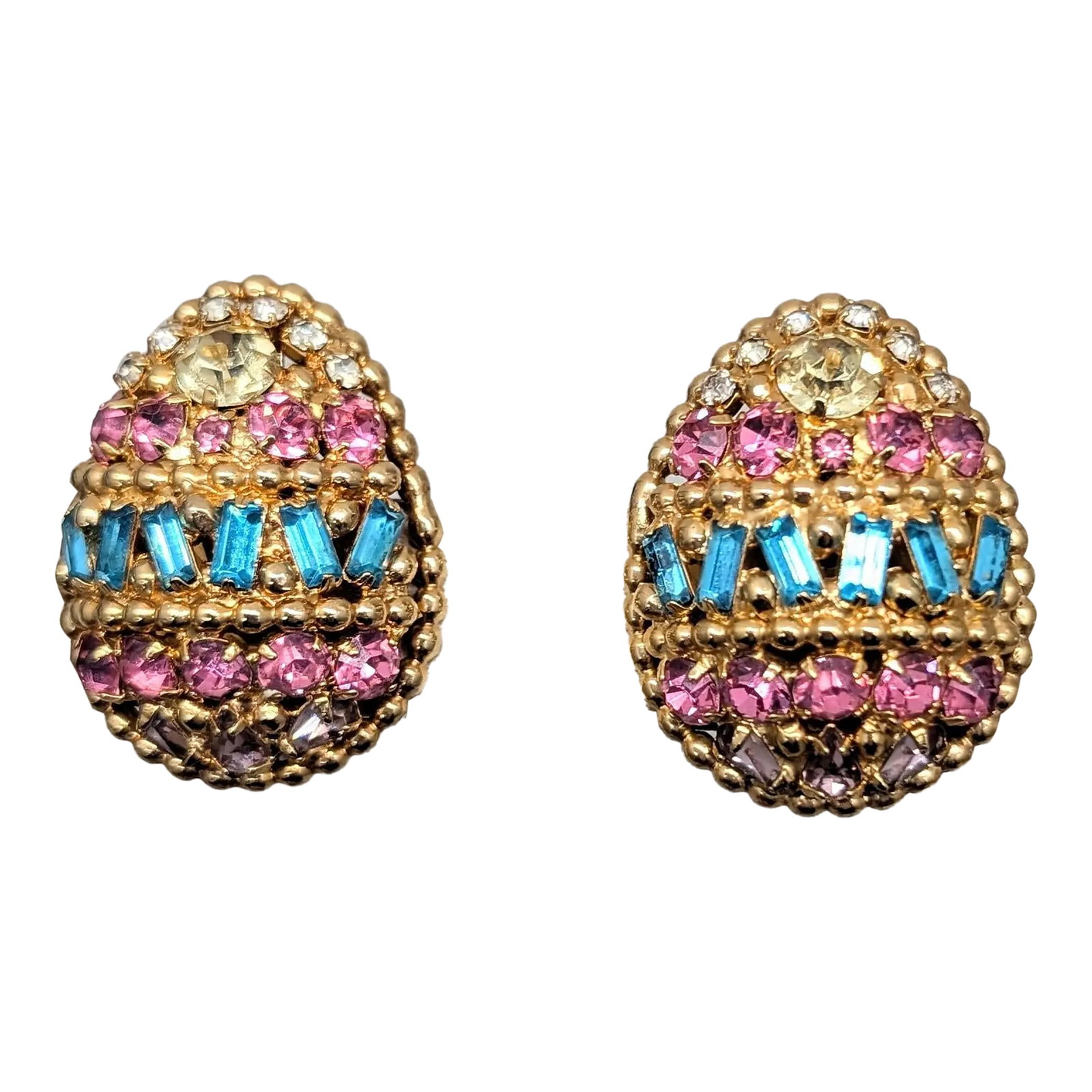 Vintage 1964 Signed Napier Ad Piece Pastel Rhinestone Easter Egg Earrings-2 Pieces: Oval goldtone round faux-pink peridot, citrine and clear rhinestones with baguette faux-aquamarines and pear shaped faux-amethyst Easter egg clip earrings. Marked "NAPIER PAT. PEND." Measure: 1 1/4