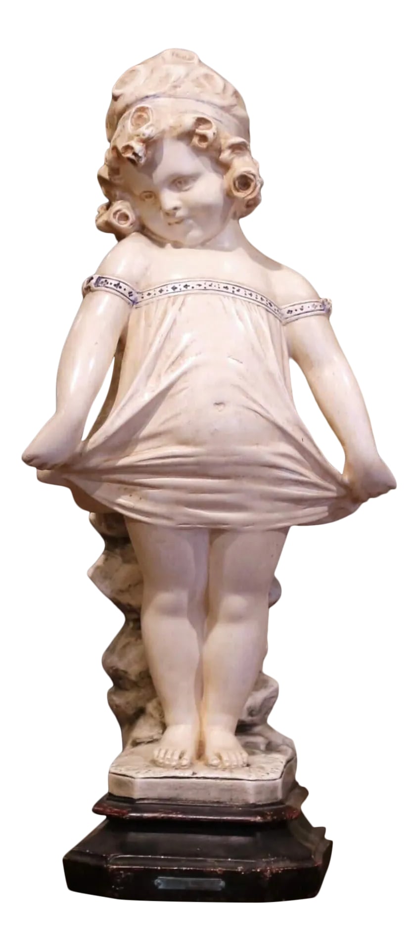 19th Century French Polychrome Plaster Figure of a Child After Donatello: Charming and expressive, this antique plaster sculpture depicts a young girl standing in a playful pose while gently holding out the folds of her dress. Crafted in France circa 1880, the figure was