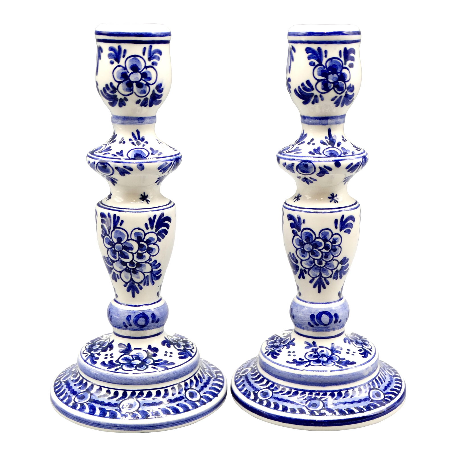 Blue & White Dutch Delft Faience Candle Holders, a Pair: A lovely pair of Mid Century Dutch Delft candlesticks. They are hand painted in the traditional colors of blue and white with a floral and foliate design. Maker's mark on the reverse. Condition: