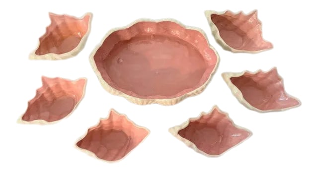 Darling Coastal Pink & White Ceramic Bowl Set- 7 Pieces: Darling set of Coastal style glazed pink and white bowls. One white serving bowl surrounded by shells and a pink center; six individual white bowls with pink centers. Bowls are hand initialed on the b