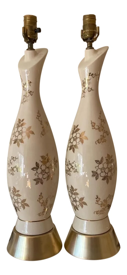 Mid Century Ceramic Table Lamps - a Pair: Statuesque ceramic in creamy white are decorated with golden blossoms and sit atop brass conical shape bases. Condition: Alterations: Original Condition Unaltered Imperfections: Some Imperfections Con