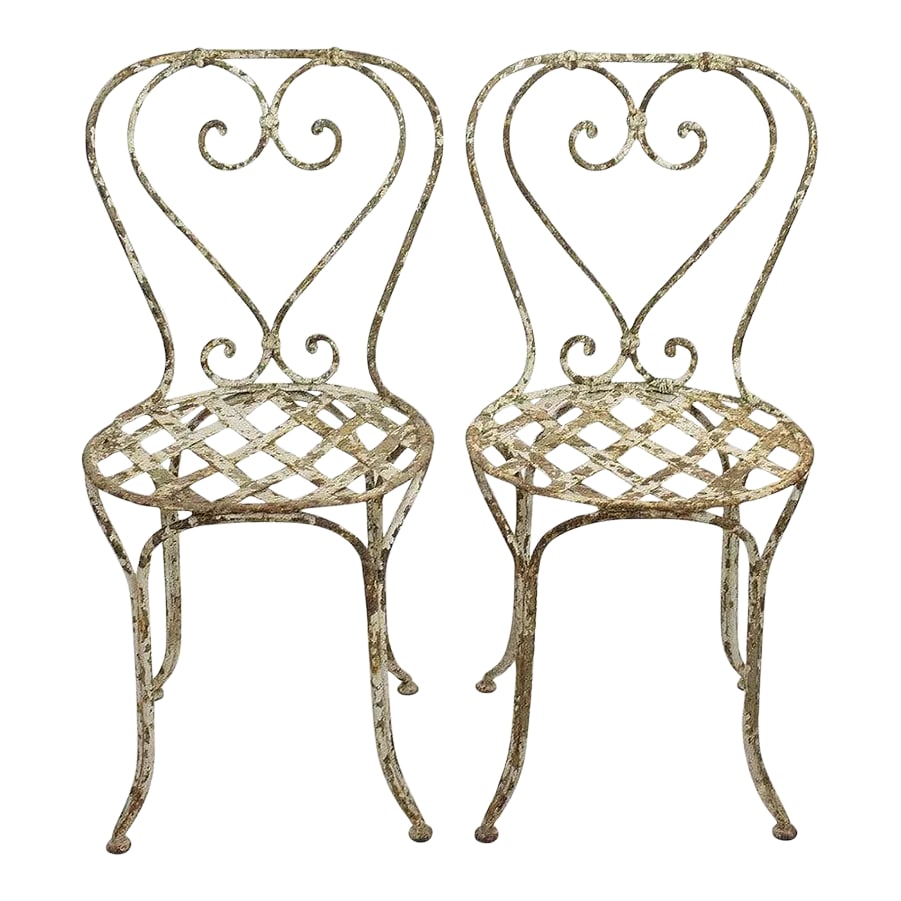 Pair of 19th Century French Painted Iron Garden Chairs: Gorgeous pair of painted iron garden chairs. In this condition and with this stunning patina very rare to find. France, circa 1850. Very weathered, lots of chipped paint but good/strong usable conditi