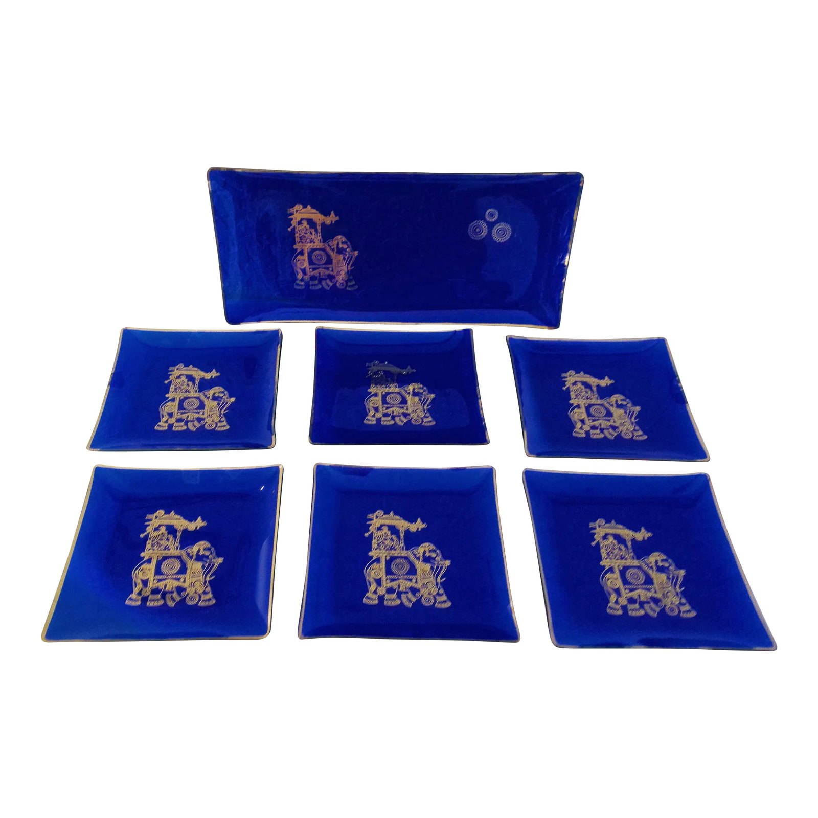 Mid-Century Cobalt Blue & Gold Royal Appetizer Trays, Set of 7: Vintage set of seven cobalt blue glass appetizer trays featuring gold rims and depicting an Indian royal elephant with man atop and "Air India" (in very small script, hardly noticeable), displayed on 
