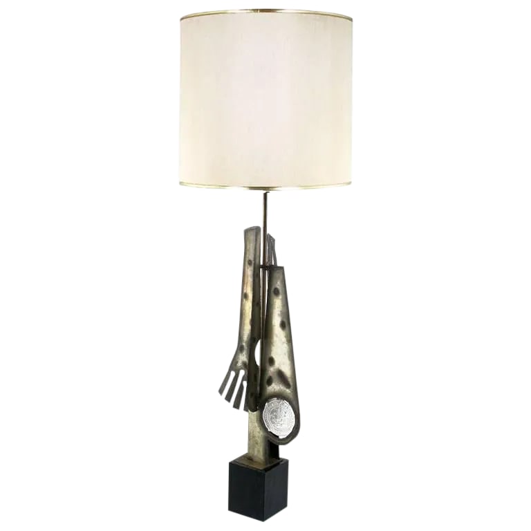Substantial Tall Brutalist Metal Sculpture Lamp by Laurel: An outstanding Brutalist lamp in torch-cut and patinated metal by Laurel Lamp. An unusual textured cast glass disc is featured. The base is a black lacquered metal plinth. Sold sans shade. Measures: 5
