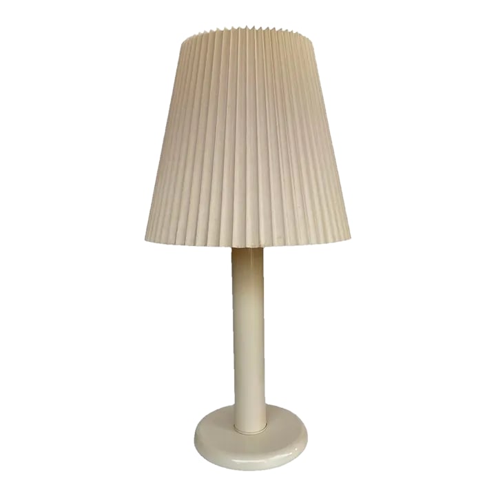 1980s Enamel Ivory Table Lamp With Original Pleated Shade - A Pair: Fabulous Post Modern table lamp in the color ivory. Offers an enamel base and original pleated shade. Condition: Alterations: Original Condition Unaltered Imperfections: Some Imperfections Condition N
