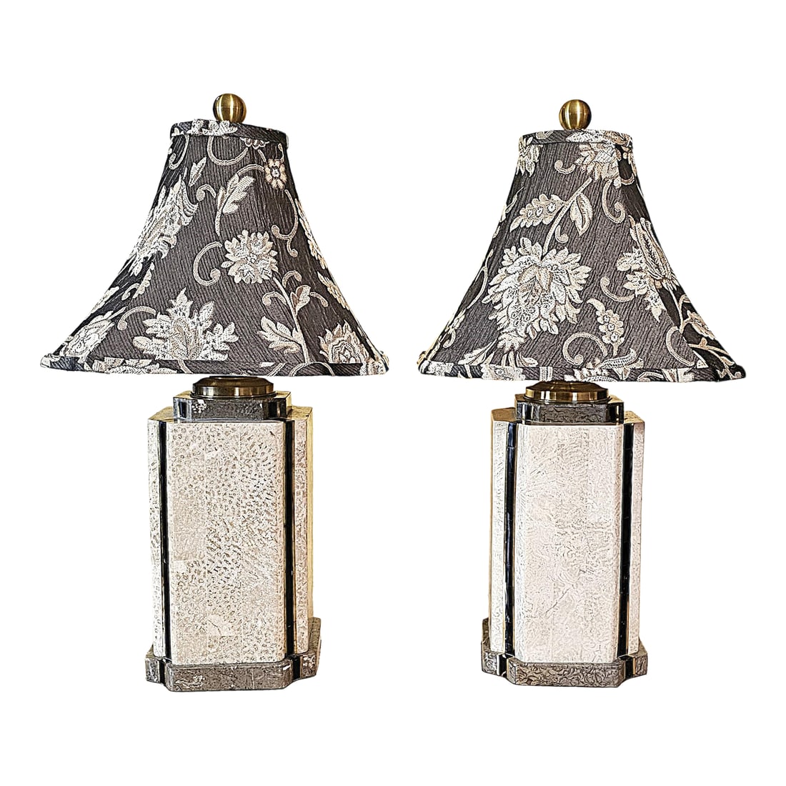Pair of Wildwood Travertine & Brass Table Lamps With Black Floral Bell Shades: Elevate your interiors with this sophisticated pair of table lamps by Wildwood, masterfully crafted in Rocky Mount, North Carolina, USA. These statement lamps feature polished travertine panels set