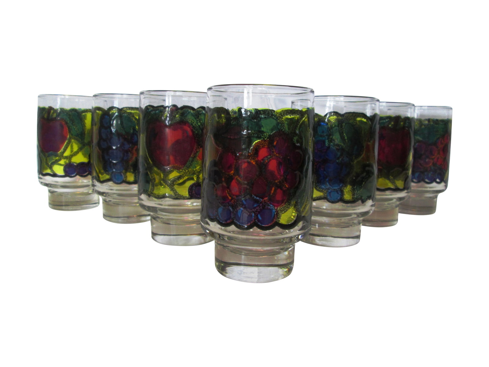 1970s Stained Glass Design Fruit Tumblers - Set of 7: Colorful set of seven Libbey footed tumblers featuring a stained glass design raised fruit-motif around perimeter. Marked underside "L." Excellent condition. Condition: Alterations: Original Condition