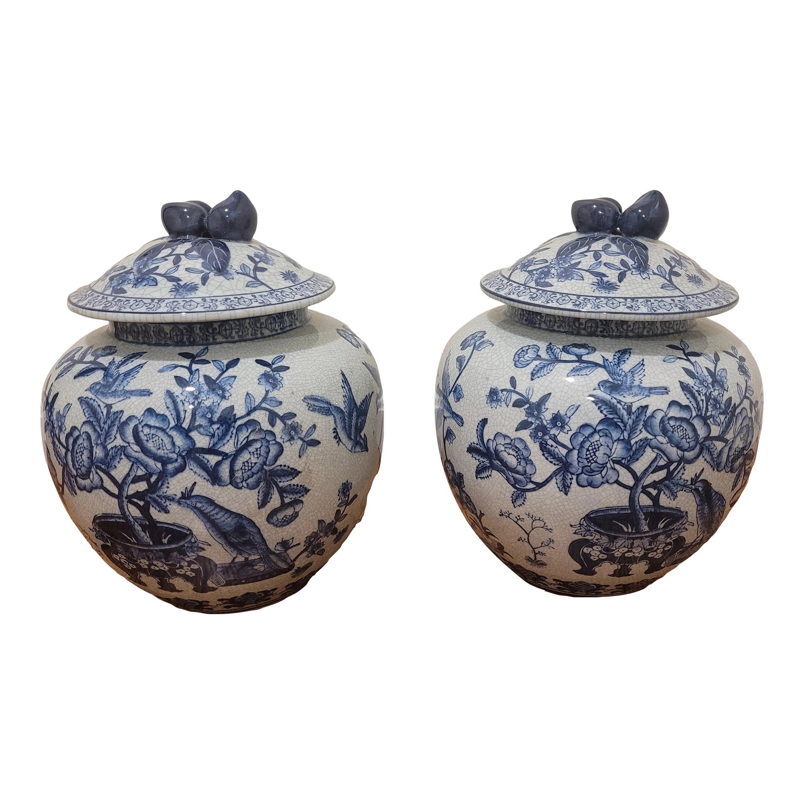 Pair of Vintage Blue and White Lidded Urns: A pair of vintage Blue and White Lidded Urns. Overall has a delicate floral pattern with exotic birds. Glaze appears consistently cracked however no chips or dings to the pottery itself. Excellent