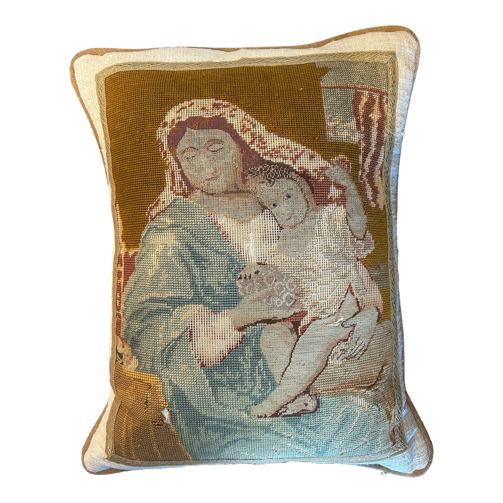 Victorian Revival Needlepoint Pillow With Religious Iconography: A stunning antique needlepoint pillow featuring the Madonna and Child. The hand stitched panel showcases soft muted tones of blue, ivory, and ochre, framed with metallic gold trim and linen sides with
