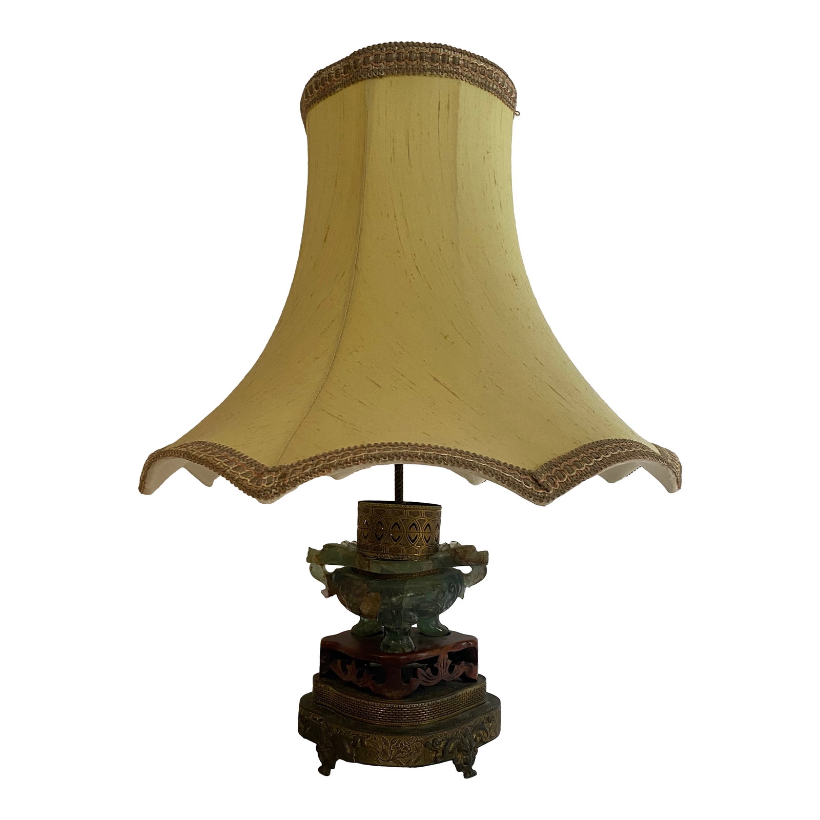 1930s Chinese Carved Jadite Lamp With Shade: Carved jade color fluorite lamp mounted on wood and brass base. Lamp holds small bulb to light the interior of the vase portion as well as a socket with pull chain.. Brass collar, trimmed silk shade. 