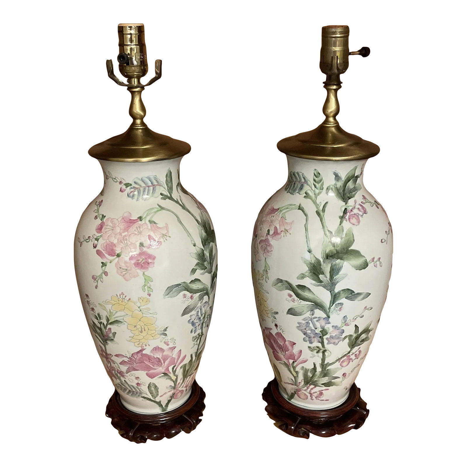 Pair of Mid-20th Century Famille Rose Ginger Jar Lamps: Beautiful pair of floral Chinese ginger jar vase lamps in Famille rose colors on white ground mounted on oriental wood bases with brass caps. Grand Millennial Condition: Alterations: Original Conditio
