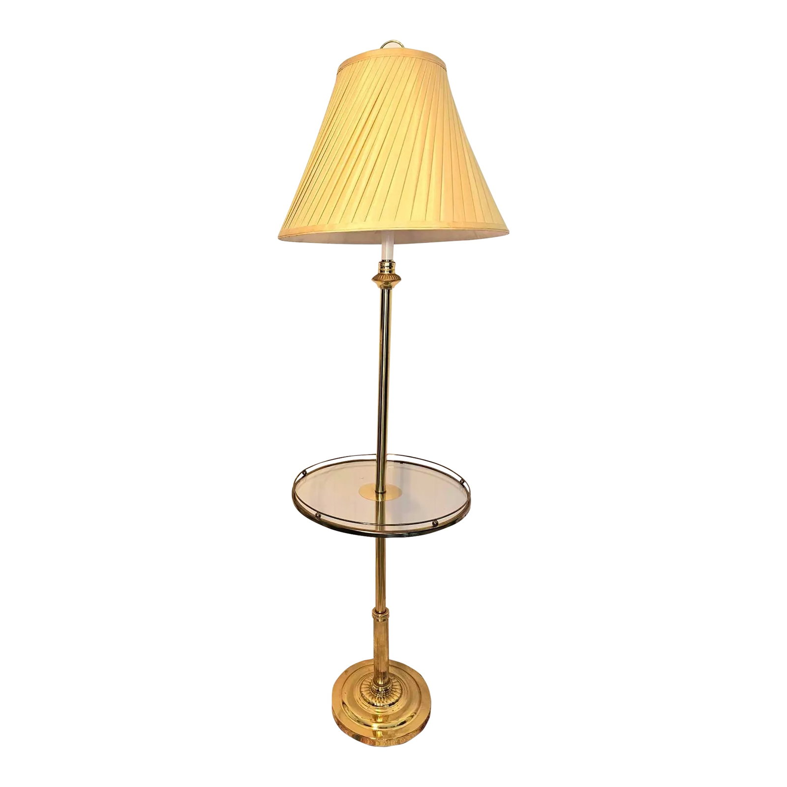 1980s Brass and Glass Floor Lamp: A classic and elegant Mid-Century Modern Table lamp. The table lamp is finely made of brass . The table features a round brass base and the table is has a glass top and is nicely framed of brass in a