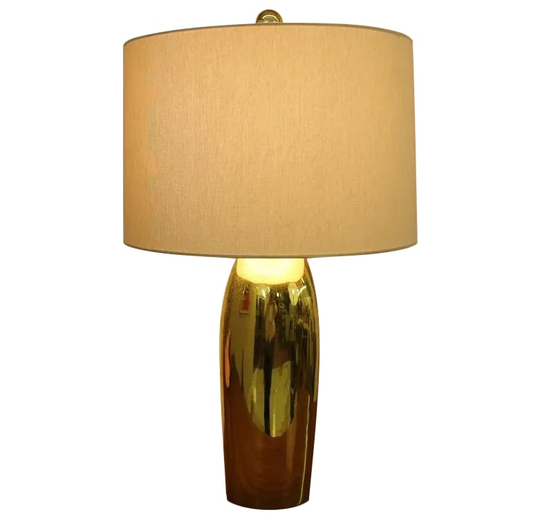 Mid-Century Modern Brass Bullet Lamp: This sophisticated brass lamp features a sleek and exquisite body with an aerodynamic form. A notched basin at the top adds interest and catches out-coming light. A round finial completes the look.