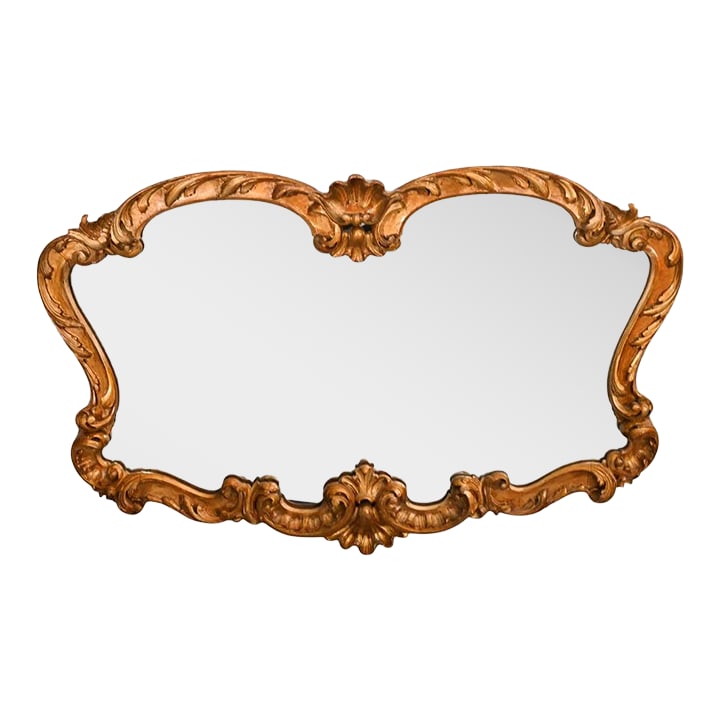 Antique Italian Hand Carved Gilt Wall Mirror: A richly carved and gilt Florentine style Italian antique mirror. The frame is hand carved and finished with a patinated gilt finish. This beautiful mirror brings a bit of classical Italian beauty to