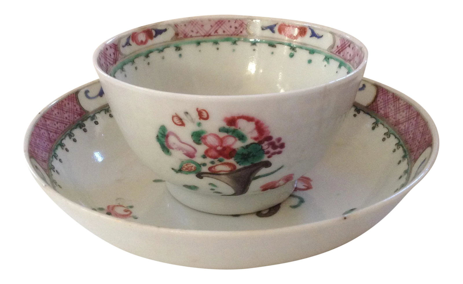 19th Century Chinese Export Tea Cup & Saucer: Antique 19th c. Chinese export porcelain tea cup and saucer. Decorated in famille rose with floral bouquets and sprigs accented with a delicate border. Stable crack in cup can barely be felt with a
