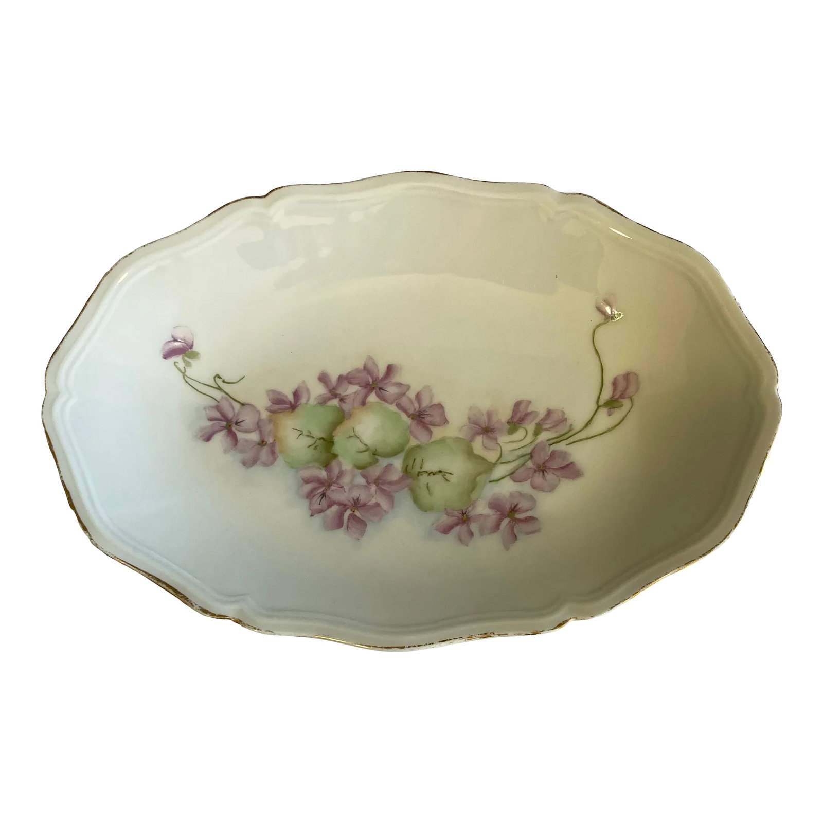 1940s Limoges Porcelain Purple Floral Dish: A charming vintage Limoges France porcelain relish dish featuring delicate hand-painted violet blossoms accented by soft green leaves. The elegant scalloped form and fine gold trim showcase the