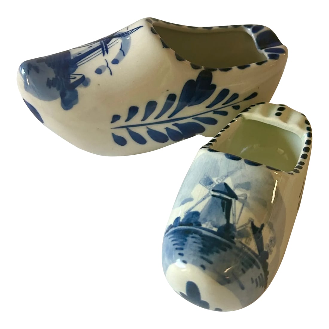 Mid 20th Century Delft Hand Painted Blue and White Ceramic Mini Clogs, Set of Two: Set of two vintage hand painted Delft Blue Ceramic Mini Clogs. These charming keepsakes from Holland, feature iconic artwork of windmills and flowers. This is not a matched set and I. Believe the