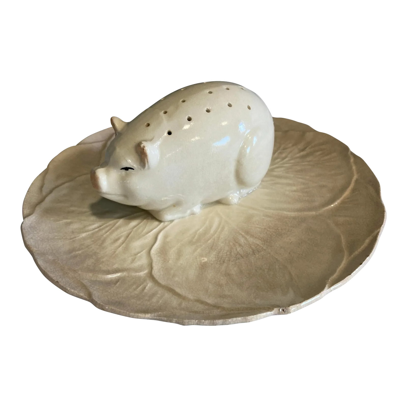 Vintage Majolica Pig Ceramic Canape Plate: Infuse your space with character and charm with this whimsical vintage ceramic pig canape holder, shaped like a peacefully sleeping pig atop a textured leaf dish. Crafted in soft cream ceramic with