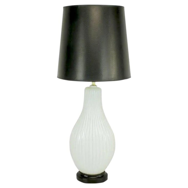 Murano Ribbed Gourd-Form White Opaline Glass Table Lamp: Ribbed and opaline Murano glass table lamp with black lacquered metal base. Elongated gourd form body with vertical ribbing. Brass stem and double socket cluster. Sold sans shade. Condition: