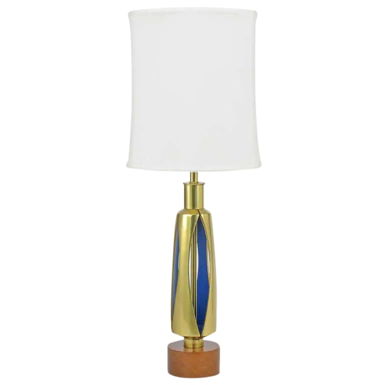 1950s Rembrandt Brass & Azure Blue Table Lamp: Unique open body brass table lamp from the Rembrandt Lighting Masterpiece collection. The four part body has vertical eyelet openings that reveal the azure blue lacquered underside. Walnut base with o