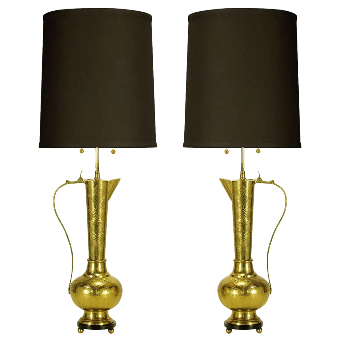 Large Moroccan Etched Brass Ewer Table Lamps - a Pair: Pair of cast and etched brass ewers, or carafes, converted to table lamps. Black lacquered wood base with brass ball feet. Brass stem and dual socket cluster with brass ball pull chain. Sold sans shad