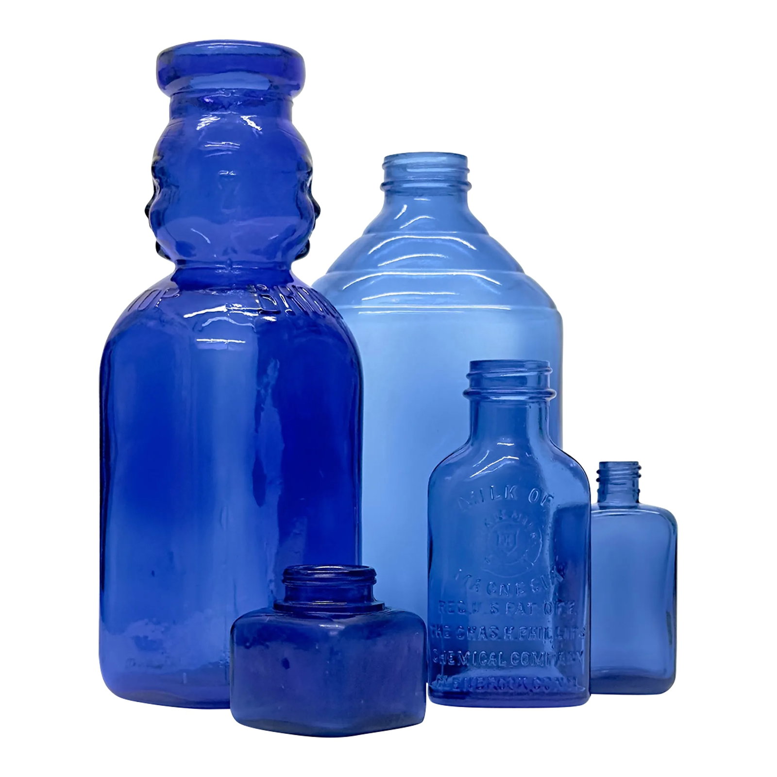 Blue Vintage Apothecary Bottle Curation - Group of 5: Cobalt blue glass bottles, group of 5. A curated group of cobalt blue apothecary bottles in a variety of shapes and sizes, featuring a vintage Phillips-Milk of Magnesia bottle. Shortest: 2"H Tallest: